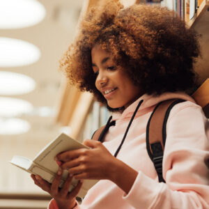 Menina lendo um livro antes de fazer um curso de inglês