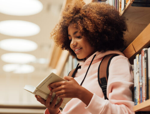 Menina lendo um livro antes de fazer um curso de inglês